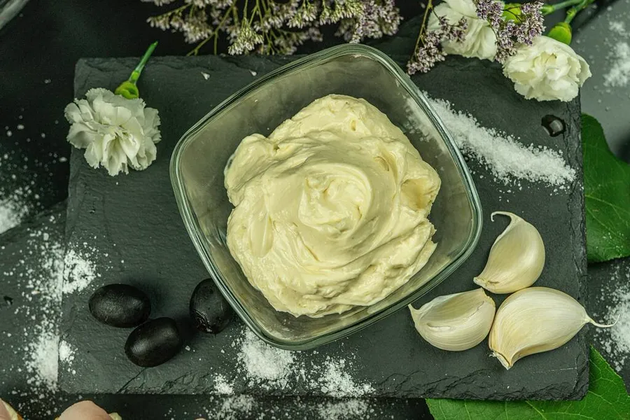Mayonesa cruda casera con aceite de oliva en bowl de vidrio